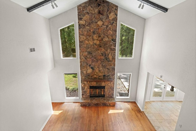 unfurnished living room featuring baseboards, a wealth of natural light, visible vents, and wood finished floors