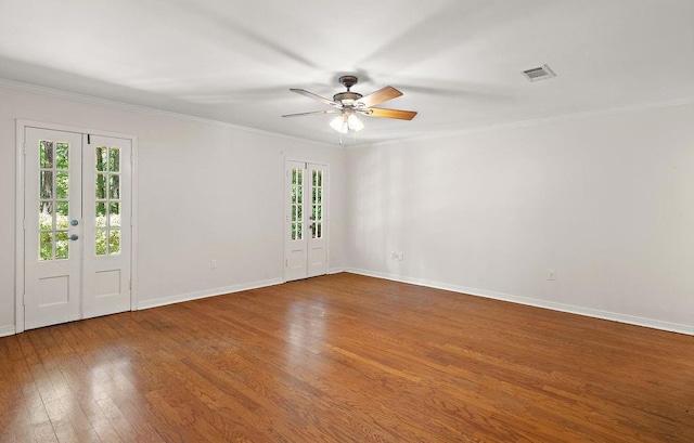 empty room featuring baseboards, ceiling fan, crown molding, and visible vents