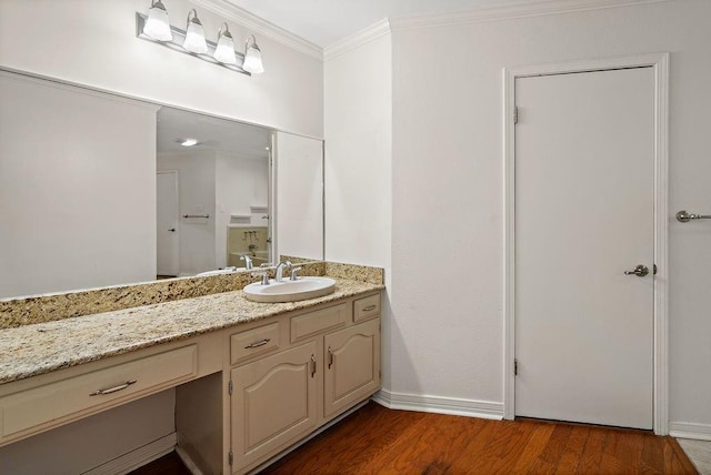 bathroom with baseboards, ornamental molding, vanity, and wood finished floors