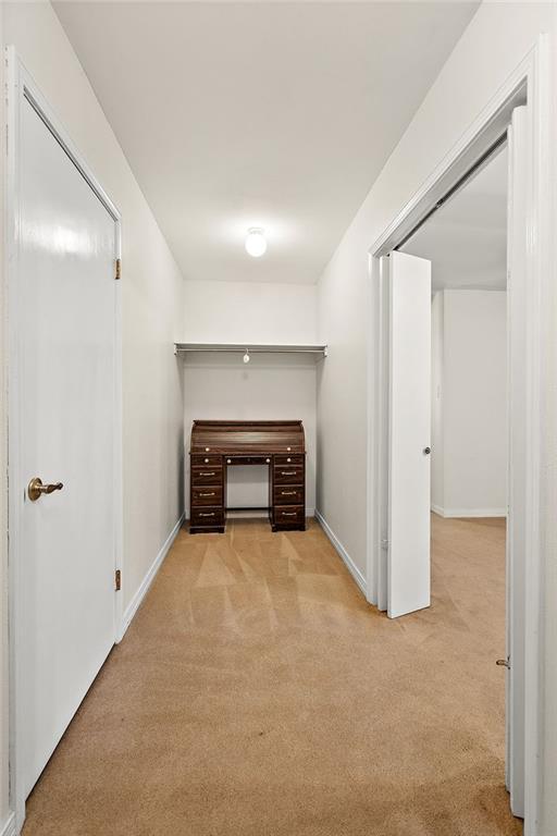 corridor with carpet floors and baseboards