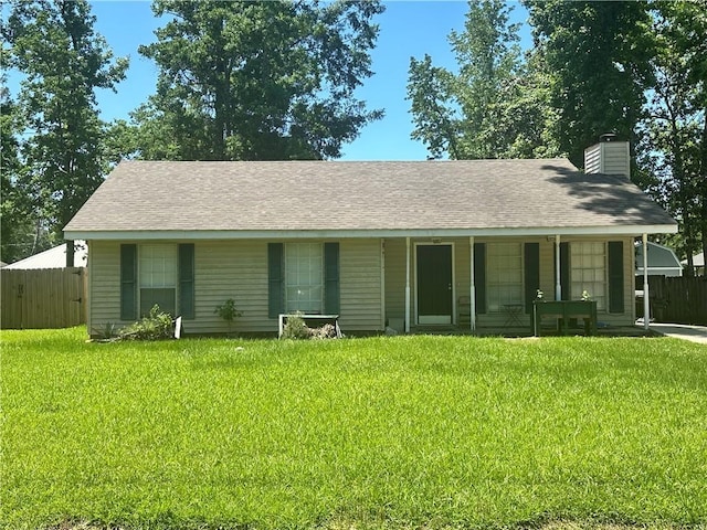 view of front of house featuring a front lawn, a porch, a chimney, and fence