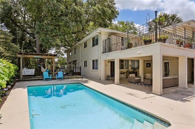35 Thrasher St, New Orleans, LA 70124 - back of property with a balcony, outdoor lounge area, a patio area, and an outdoor pool