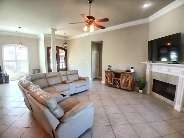 living area featuring baseboards, ceiling fan, light tile patterned flooring, crown molding, and a tile fireplace