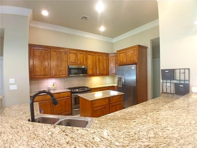 kitchen with a sink, visible vents, appliances with stainless steel finishes, decorative backsplash, and ornamental molding