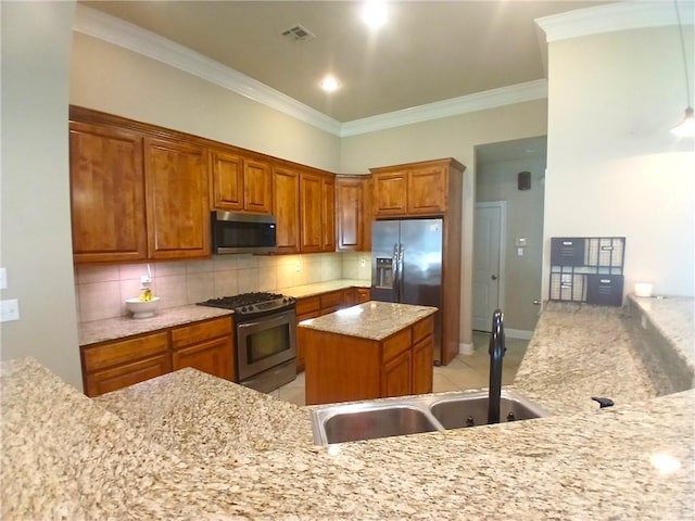 kitchen featuring visible vents, a sink, decorative backsplash, brown cabinets, and stainless steel appliances