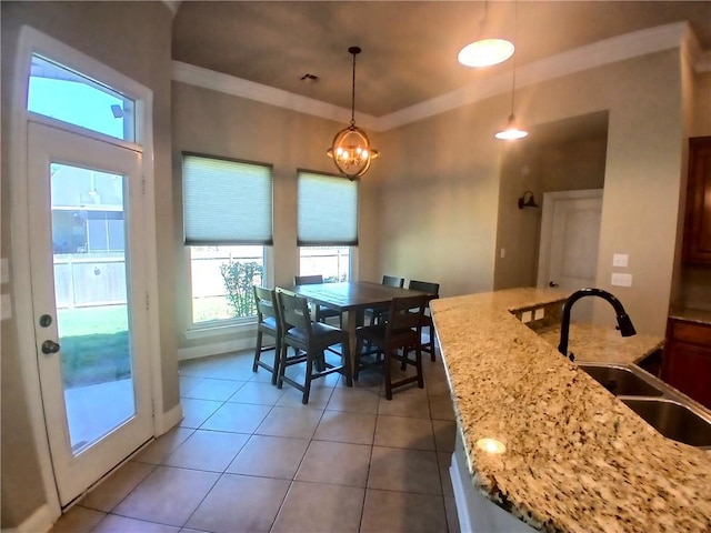 dining space featuring light tile patterned floors, a notable chandelier, ornamental molding, and baseboards