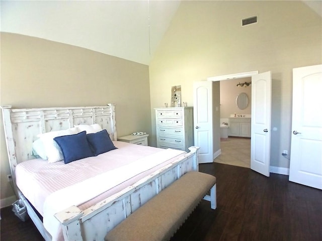 bedroom featuring dark wood finished floors, visible vents, baseboards, and high vaulted ceiling