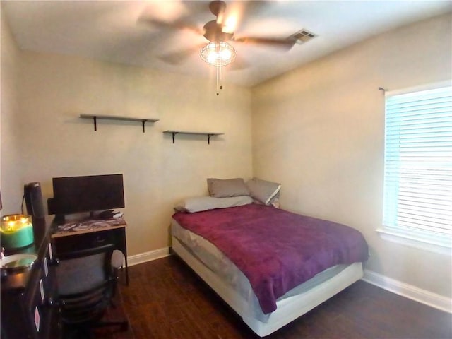 bedroom featuring ceiling fan, baseboards, visible vents, and wood finished floors