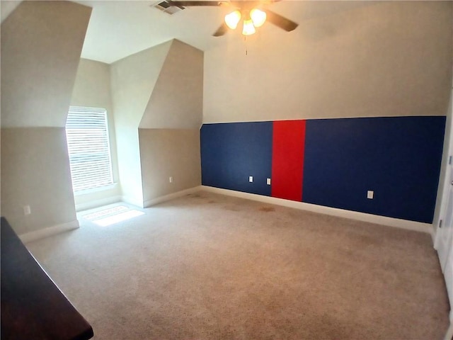 additional living space with lofted ceiling, carpet, visible vents, a ceiling fan, and baseboards