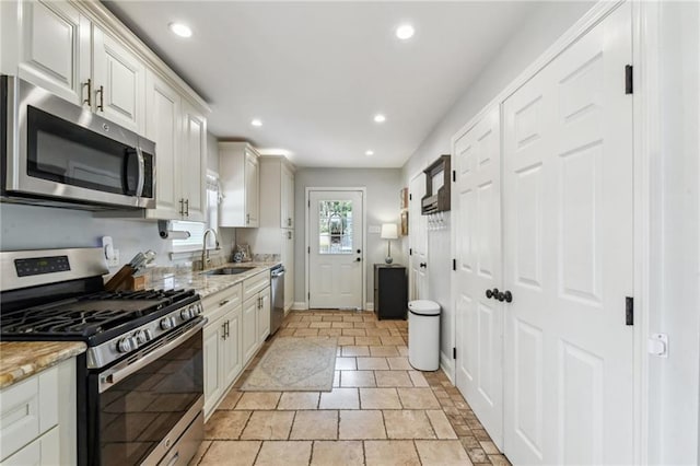 kitchen with recessed lighting, stainless steel appliances, baseboards, and a sink