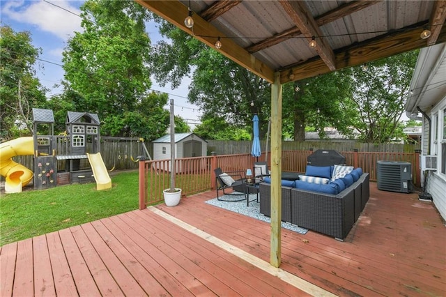 wooden deck with a playground, a fenced backyard, an outdoor living space, and a shed