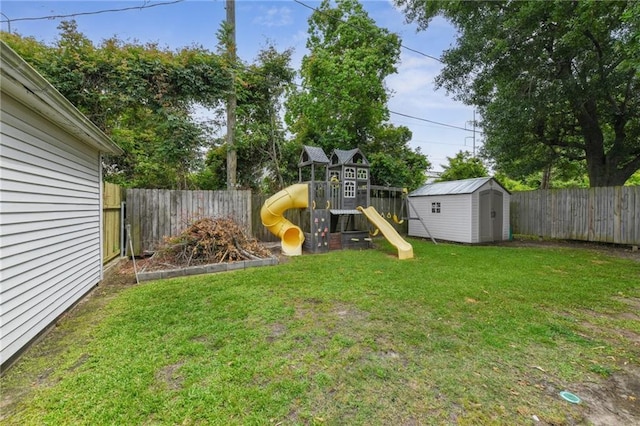 view of yard with a playground, a shed, an outdoor structure, and a fenced backyard