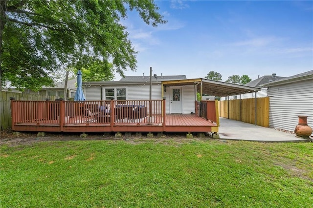 rear view of property with a yard, fence, and a deck