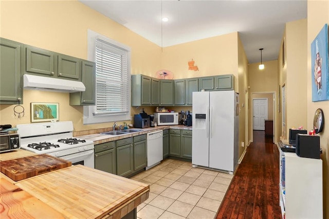 41719 S Genois St, New Orleans, LA 70119 - kitchen with green cabinetry, white appliances, light countertops, and under cabinet range hood