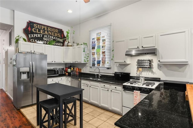 41719 S Genois St, New Orleans, LA 70119 - kitchen featuring dark stone countertops, a sink, white cabinets, under cabinet range hood, and appliances with stainless steel finishes