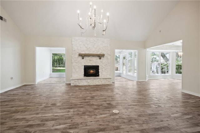 68 Begonia Dr, Covington, LA 70433 - unfurnished living room with a notable chandelier, baseboards, dark wood-style floors, and high vaulted ceiling