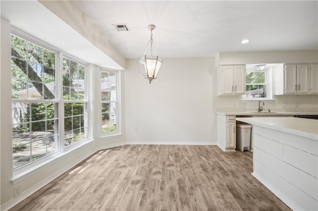 68 Begonia Dr, Covington, LA 70433 - kitchen featuring a sink, light wood-style flooring, white cabinetry, light countertops, and baseboards