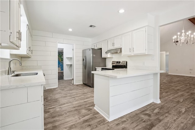 68 Begonia Dr, Covington, LA 70433 - kitchen featuring wood finished floors, a sink, white cabinetry, under cabinet range hood, and appliances with stainless steel finishes