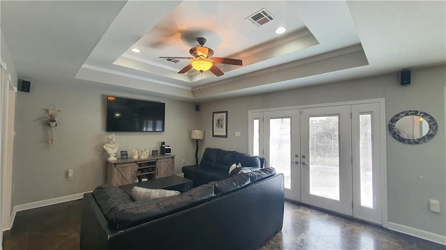 living area with a tray ceiling, ceiling fan, french doors, ornamental molding, and baseboards