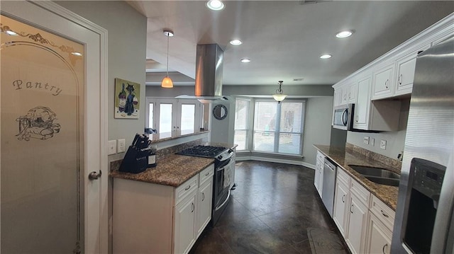 kitchen with appliances with stainless steel finishes, recessed lighting, island range hood, white cabinets, and a sink
