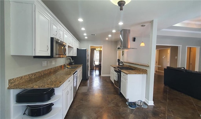 kitchen with stainless steel appliances, wall chimney exhaust hood, white cabinets, a sink, and recessed lighting