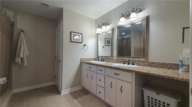 bathroom with double vanity and baseboards