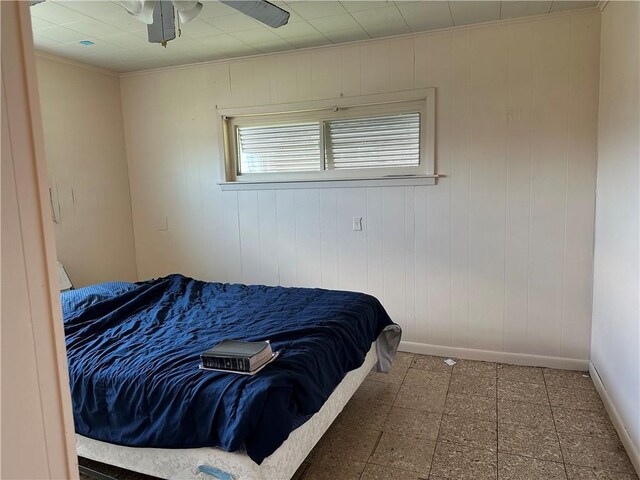 3024 Kansas St, New Orleans, LA 70114 - bedroom with baseboards, ceiling fan, wooden walls, tile patterned floors, and crown molding