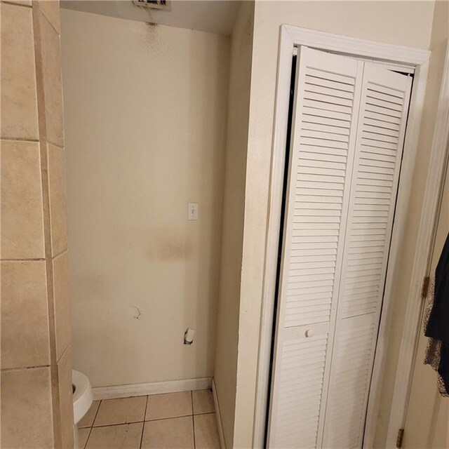 3024 Kansas St, New Orleans, LA 70114 - bathroom with a closet, toilet, tile patterned flooring, and baseboards