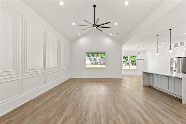 unfurnished living room with light wood finished floors, baseboards, ceiling fan, lofted ceiling, and recessed lighting
