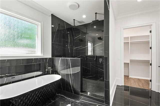 full bathroom featuring marble finish floor, a marble finish shower, recessed lighting, a walk in closet, and a freestanding tub