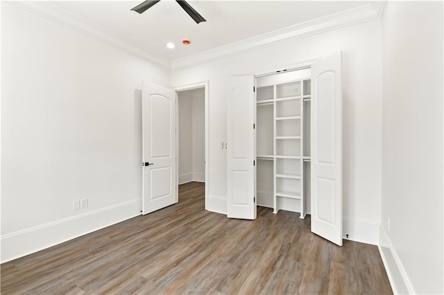 unfurnished bedroom featuring a closet, wood finished floors, crown molding, ceiling fan, and baseboards