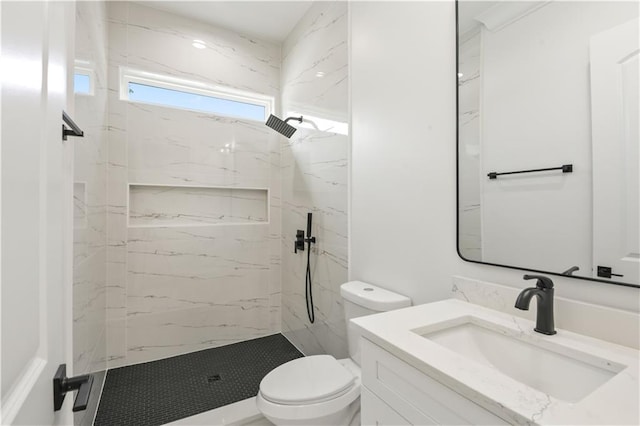 bathroom featuring toilet, a marble finish shower, and vanity
