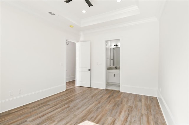unfurnished bedroom featuring recessed lighting, ornamental molding, visible vents, a raised ceiling, and light wood-type flooring