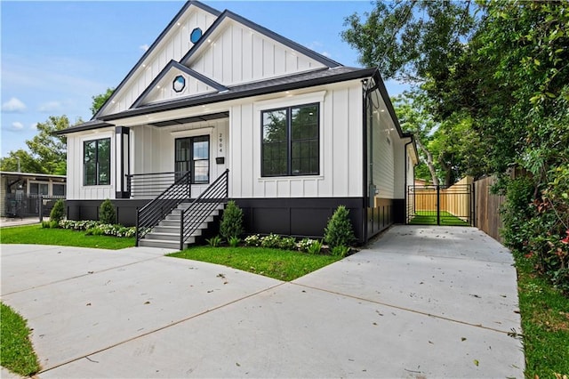 2904 Green Acres Rd, Metairie, LA 70003 - modern inspired farmhouse with board and batten siding, concrete driveway, and fence