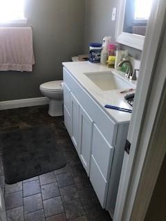 362 W Ave, Harahan, LA 70123 - bathroom featuring toilet, baseboards, vanity, and stone finish floor