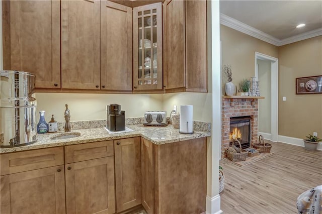 929 W 17th Ave, Covington, LA 70433 - bar with a sink, a fireplace, crown molding, light wood finished floors, and baseboards