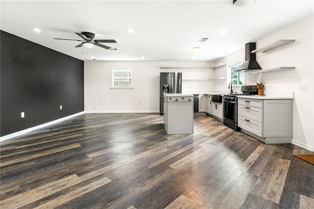 kitchen featuring dark wood-style floors, stainless steel appliances, open shelves, and wall chimney exhaust hood
