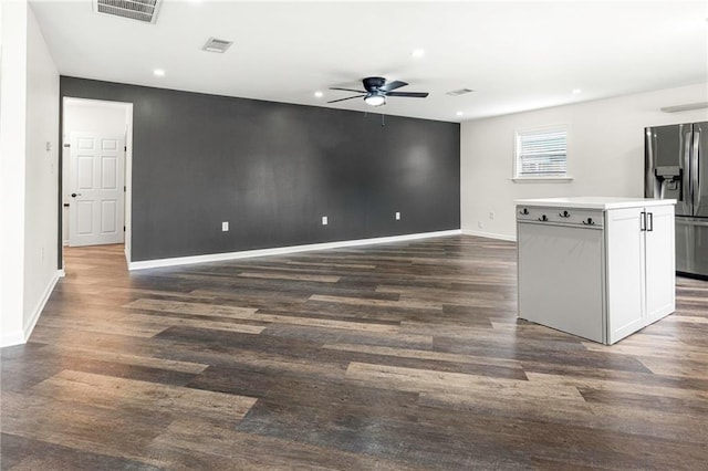 interior space with a ceiling fan, baseboards, and visible vents