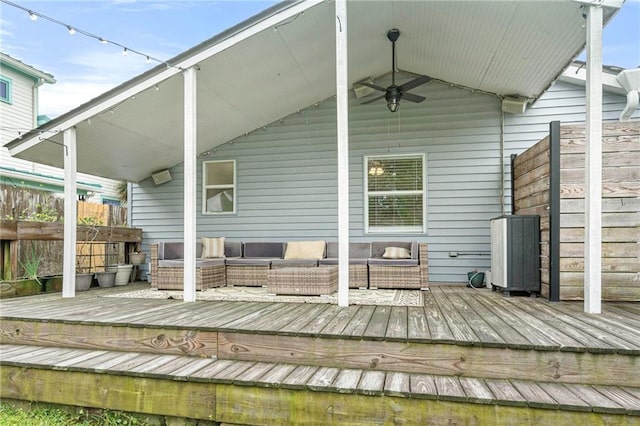 wooden deck with an outdoor living space, a ceiling fan, and fence