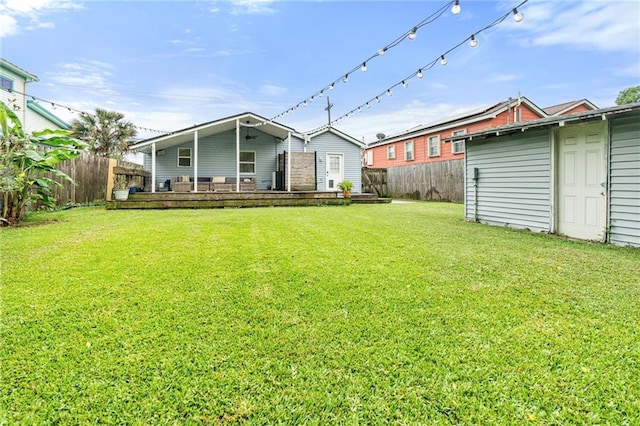 back of house with a fenced backyard, an outdoor structure, and a lawn