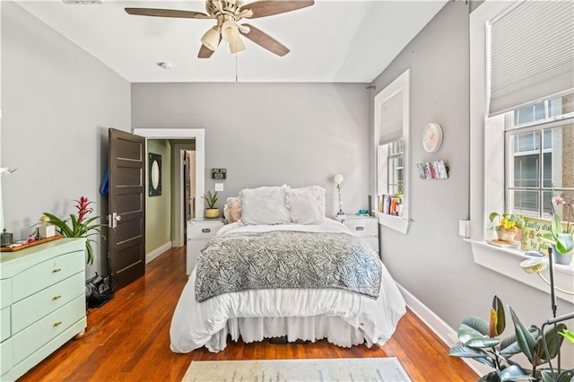 bedroom with wood finished floors, baseboards, and ceiling fan
