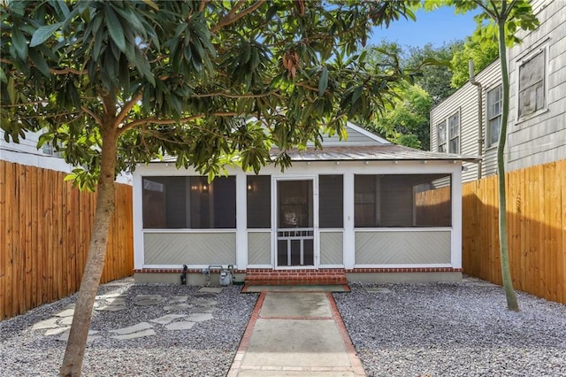 back of property with a sunroom and fence