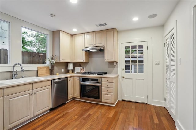 kitchen with light wood-style flooring, a sink, stainless steel appliances, visible vents, and light countertops