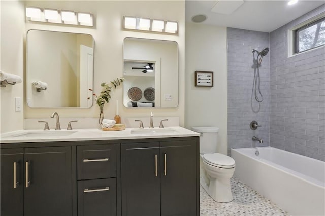 bathroom featuring double vanity, toilet, shower / bath combination, and a sink