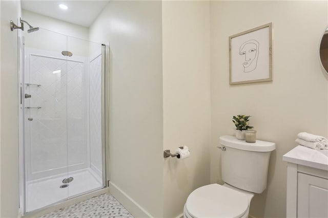 bathroom featuring vanity, toilet, baseboards, and a stall shower