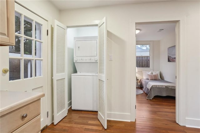 laundry room featuring light wood-type flooring, visible vents, laundry area, and stacked washer and clothes dryer