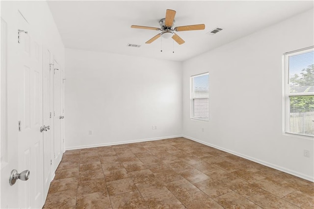 spare room with a ceiling fan, baseboards, and visible vents