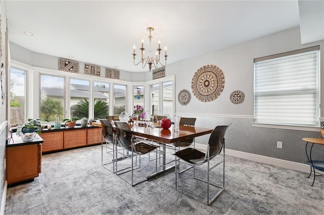 dining area featuring a chandelier, light carpet, and baseboards