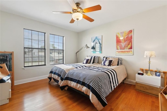 bedroom with baseboards, wood finished floors, and a ceiling fan