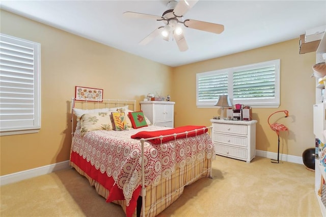 bedroom with light carpet, a ceiling fan, and baseboards